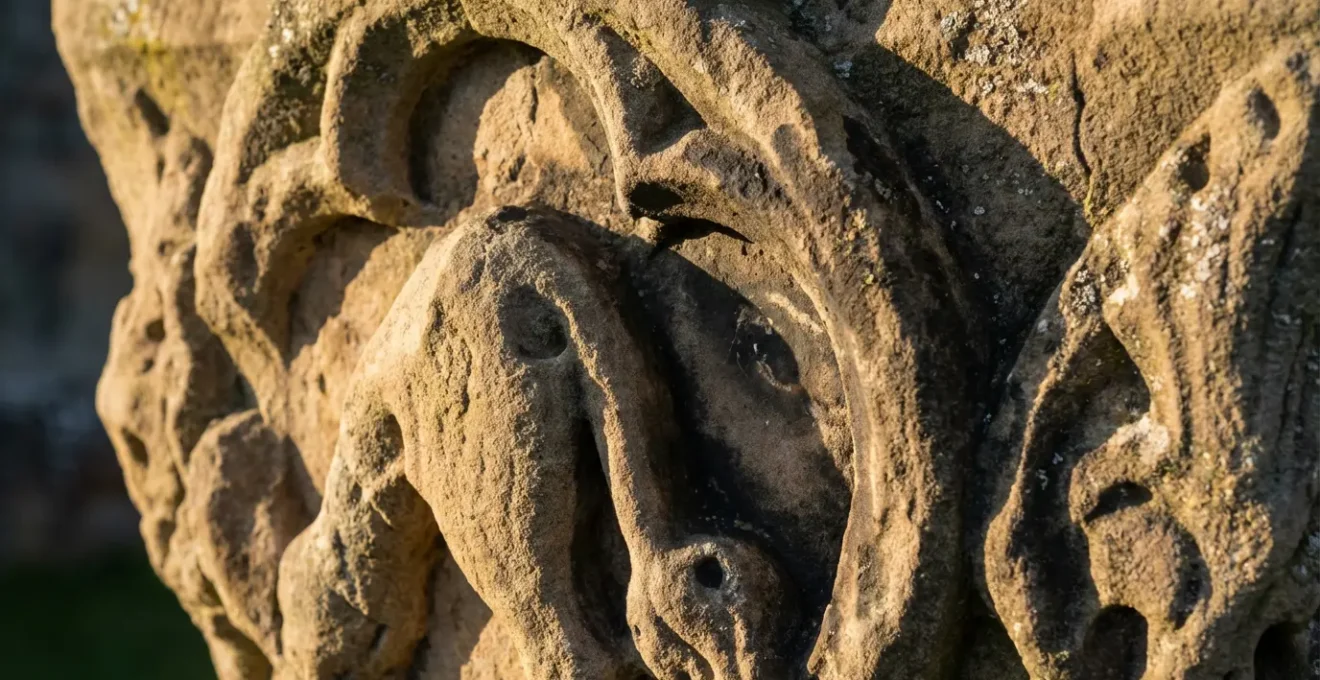 Gros plan sur une pierre sculptée montrant l'érosion progressive due aux contacts répétés